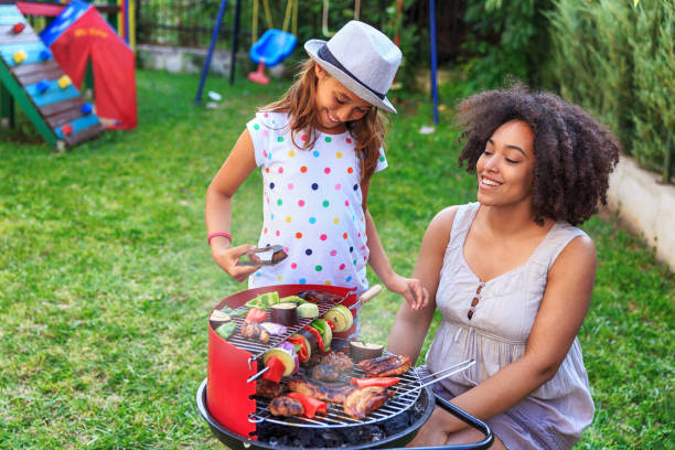 istock Girl making barbecue at backyard with her mom 823708670