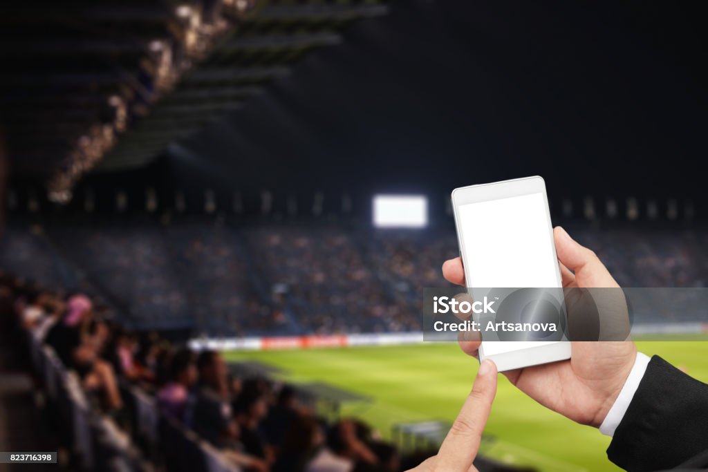 hand hold mobile hand hold mobile with football match Soccer Stock Photo