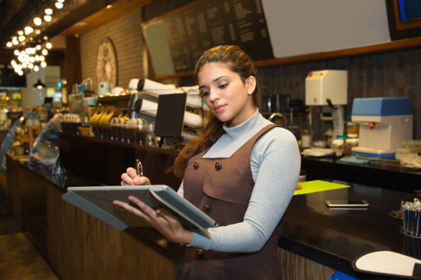 istock Confident cafe owner writing in register book 823718738
