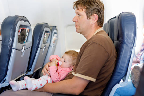 istock Young tired father carry his baby daughter during flight on airplane. 823730498