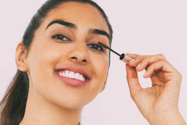 istock Smiling Indian Woman Applying Mascara 823736504