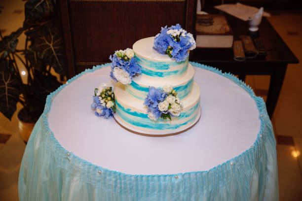 istock Multilevel wedding cake on white table. Sweets in white and blue colour. Top view 823736712