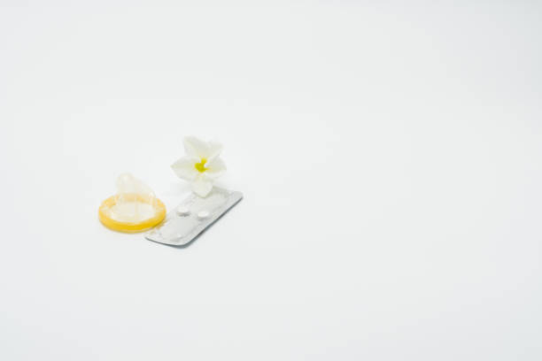 콘돔과 흰색 배경에 꽃 응급 피임약 - contraceptive sex education birth control pill condom 뉴스 사진 이미지