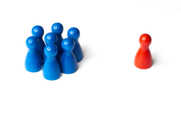 One Group of seven blue people and one red person. Game figure concept. symbol for a conflict between two groups of people two groups stock pictures, royalty-free photos & images