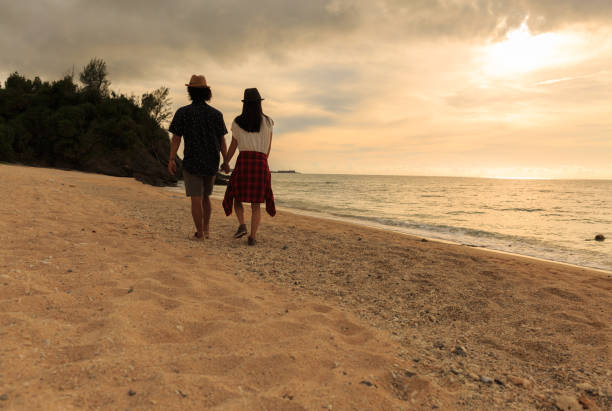 istock A couple walks on a sandy beach. 823737822