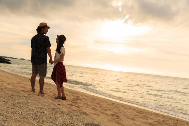 istock A couple walks on a sandy beach. 823737828