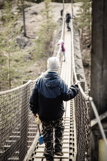 istock Boy is walking on a hanging bridge in the forest 823738278