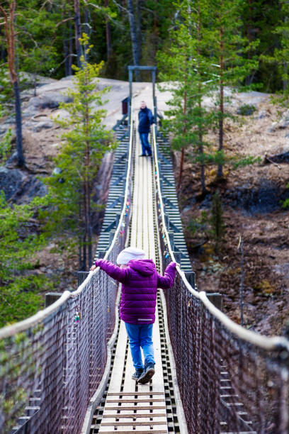 istock Girl is walking on a hanging bridge in the forest 823738292