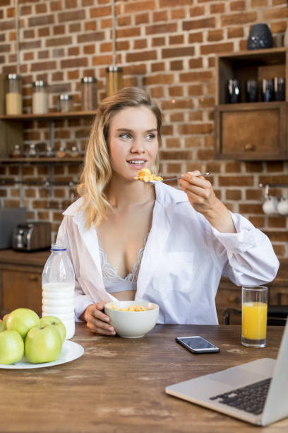 istock Young blonde woman having corn flakes on breakfast in kitchen 823741304