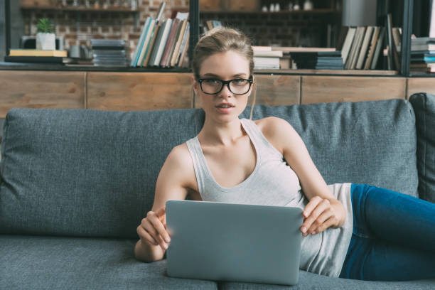 istock Young attractive woman using laptop on sofa in living room 823743714