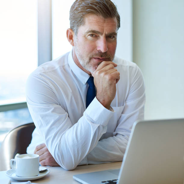 istock Handsome business leader looking serious with laptop in office 823763096