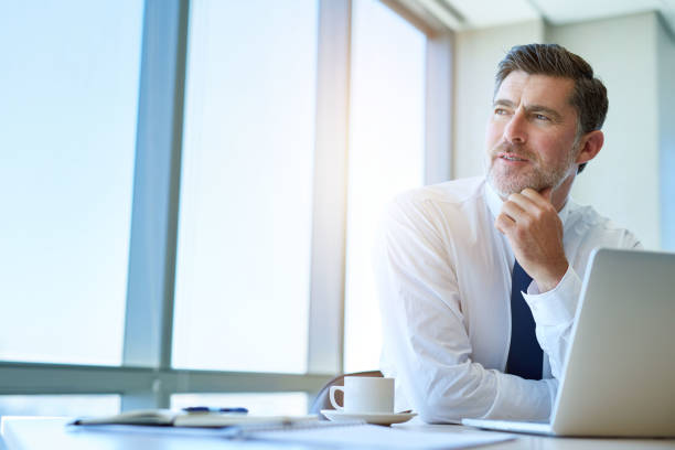 istock Business executive looking thoughtfully out of his office window 823763426