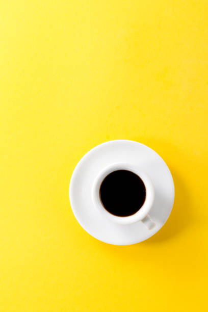 istock Coffee espresso in small white ceramic cup on yellow vibrant background. Minimalism Food Morning Energy Concept. 823763790