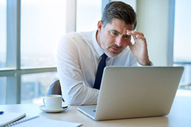 istock Mature businessman looking worriedly at his laptop computer 823764294