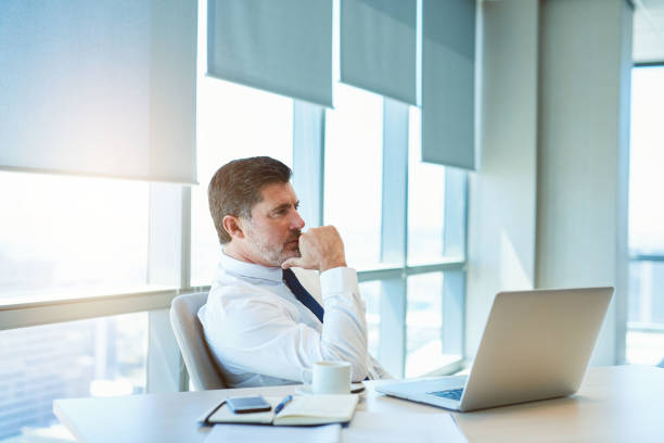istock Mature business manager sitting thinking at his desk 823767000