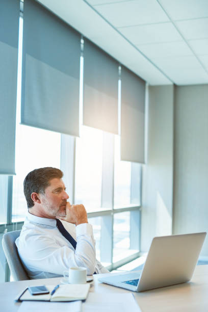 istock Mature corporate executive sitting at his desk thinking 823767134