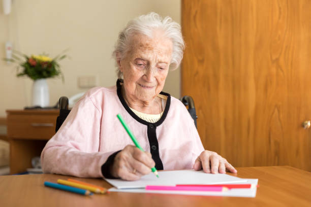 Senior woman drawing on white paper
