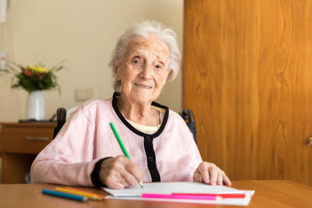 istock Senior woman drawing on white paper 823775308