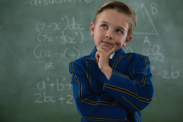 istock Schoolboy standing against chalkboard 823781286