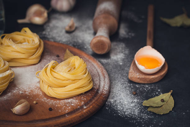 istock Raw homemade pasta with flour and spices on the rustic background. 823781386
