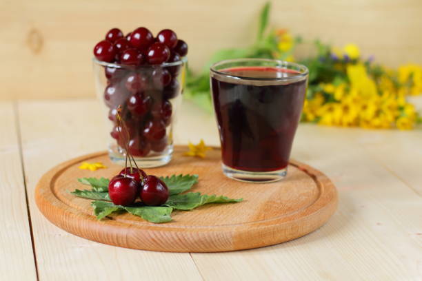 Fresh cherries and a glass of cherry juice.