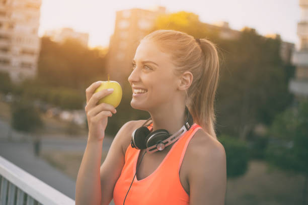 Sporty woman eating apple