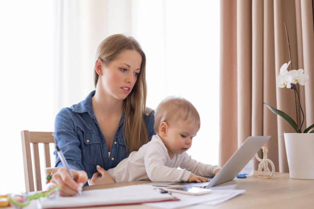 istock Working mom with child in her lap and laptop 823789496