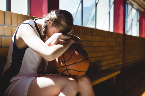 Tired basketball player sitting by window