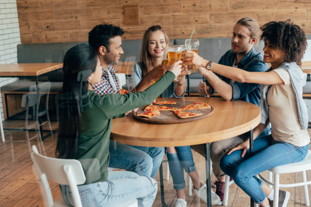 istock Group of young multiethnic friends clinking with beer in cafe 823796496