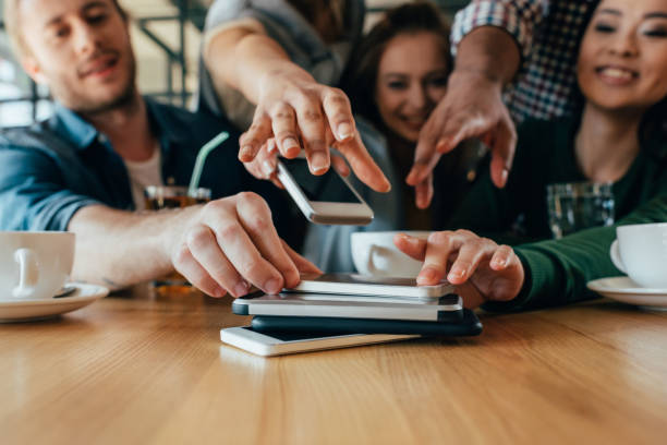 istock Young friends taking back their smartphones lying in pile on table in cafe 823799666