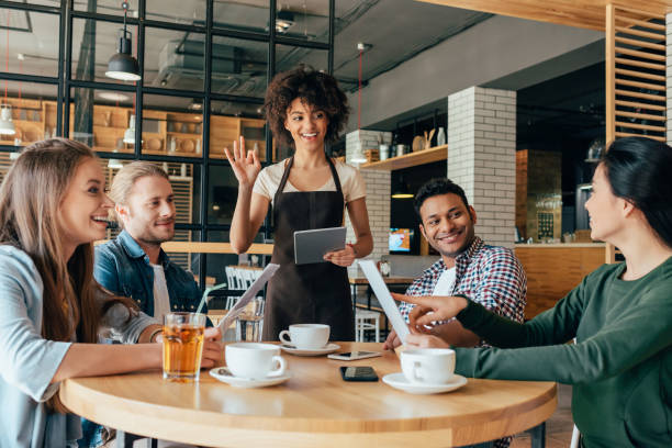 camarera joven mujer afroamericana tomar pedidos de clientes en la cafetería - waiter fotografías e imágenes de stock