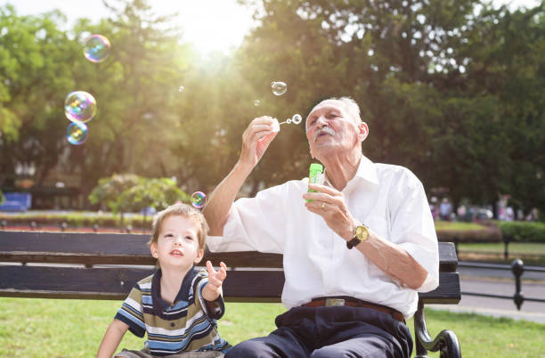 istock grandfather blowing soap bubbles to his grandchild 823806948
