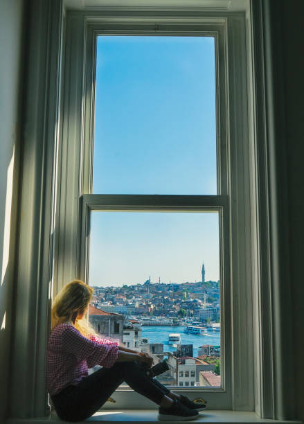 istock photographer women near window sit 823808378