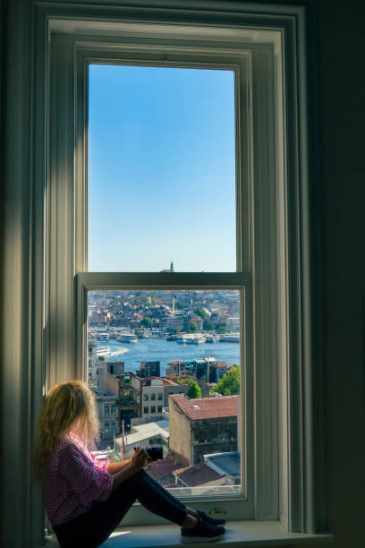 istock photographer women near window sit 823808450