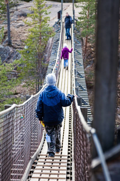 istock Boy is walking on a hanging bridge in the forest 823816456