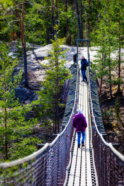 istock Girl is walking on a hanging bridge in the forest 823816464