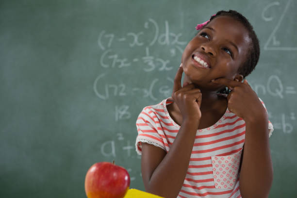 istock Schoolgirl sitting against chalkboard 823818586