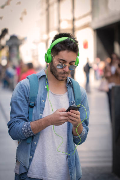 istock Smiling man texting and listening music 823819138
