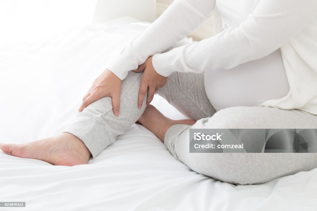 Pregnant women with cramp in leg Leg Stock Photo