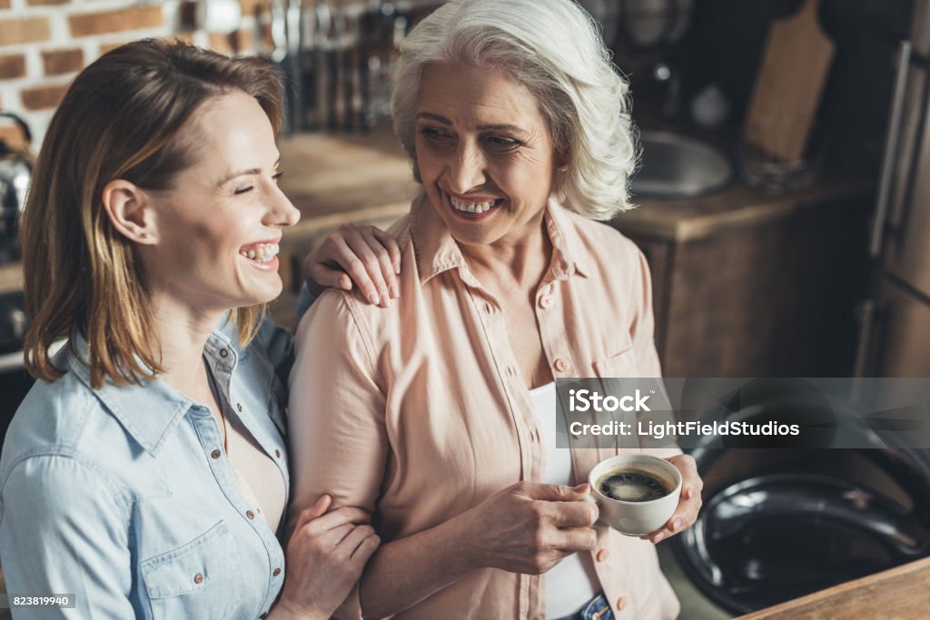 hija adulta hablando con madre superior en cocina - Foto de stock de Café - Bebida libre de derechos