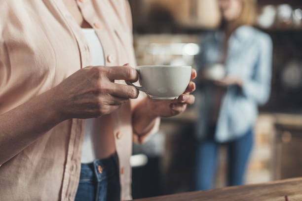 istock Cropped image, middle section of person holding coffee cup, standing in kitchen 823822882