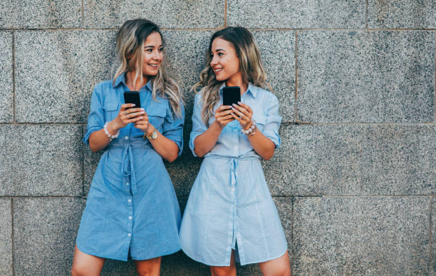 Twins texting in the city