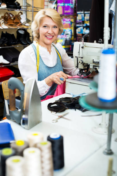 istock Mature woman sewing with professional machine 823826478
