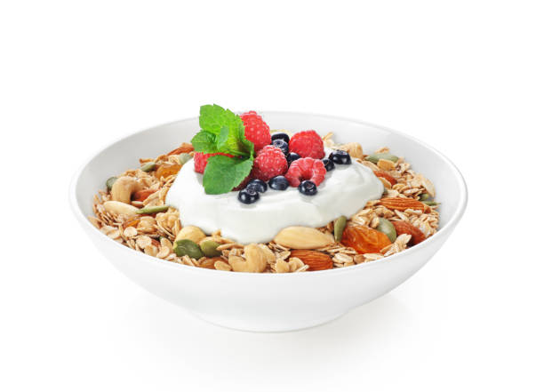 istock Muesli with fresh berries, nuts and yogurt in a bowl isolated on white background. 823827366