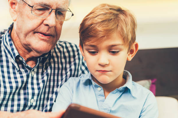 istock Boy and Grandfather Watching Cartoon on Tablet 823830476