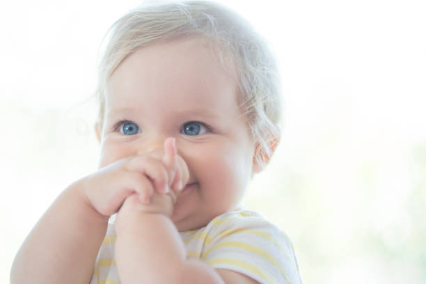 bébé mignon avec ses doigts dans sa bouche - un seul bébé fille photos et images de collection