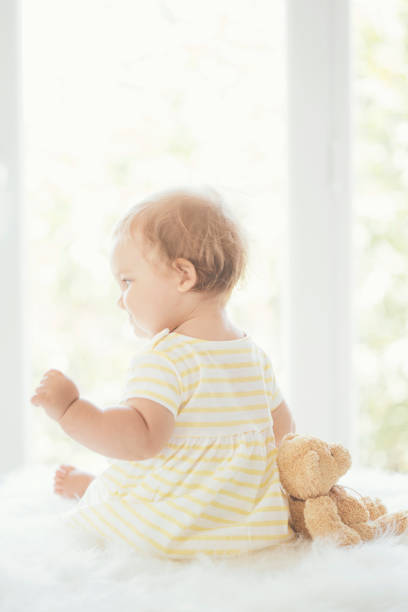 istock Cute baby sitting next to window 823831480