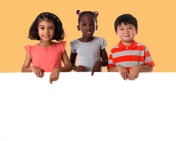 group of multiracial kids portrait with white board - preschooler childhood outdoors cheerful imagens e fotografias de stock