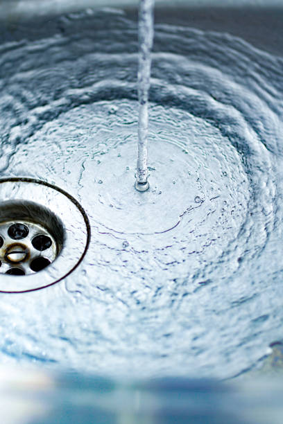 istock A jet of water pours into the kitchen sink - blue toned image 823832824