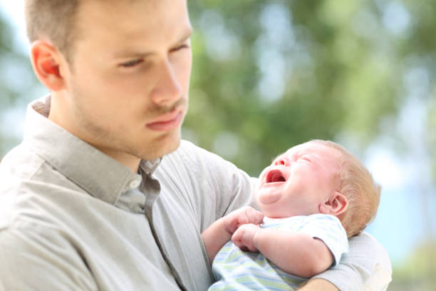 istock Baby crying and bored father 823835266